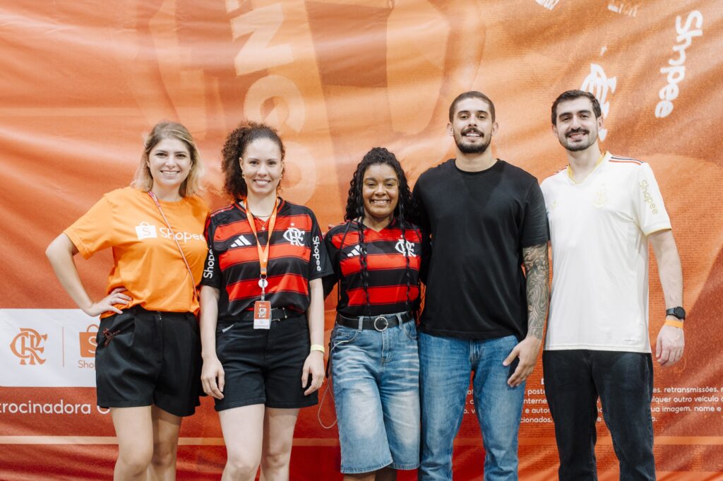 Equipe da ativação da Shopee diante do backdrop da marca com o escudo do Flamengo, no Estádio Luso-Brasileiro