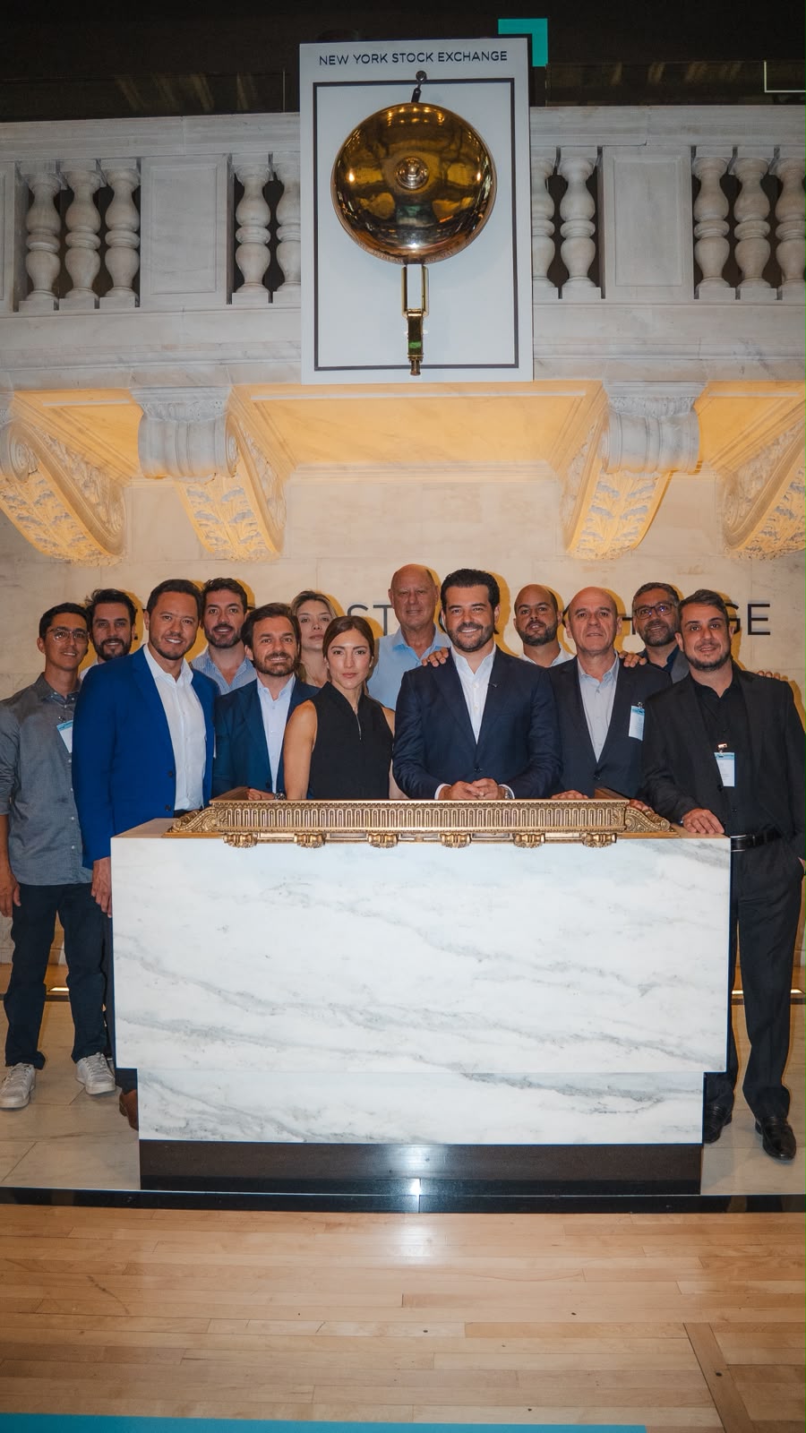 Participantes da Wall Street Experience posam no púlpito do sino da Bolsa de Nova York