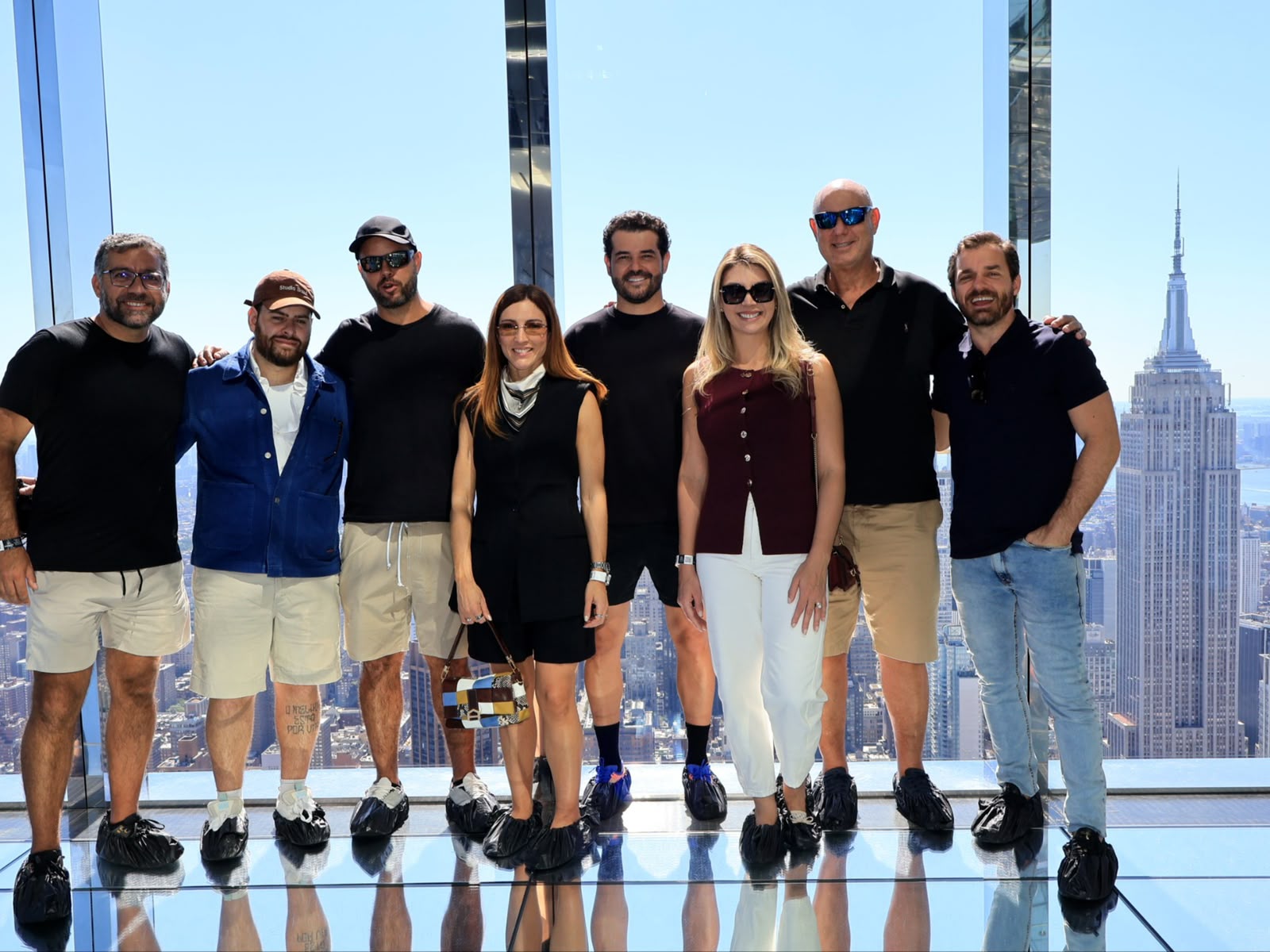 Participantes da Wall Street Experience no Summit One Vanderbilt, com o Empire State Building ao fundo